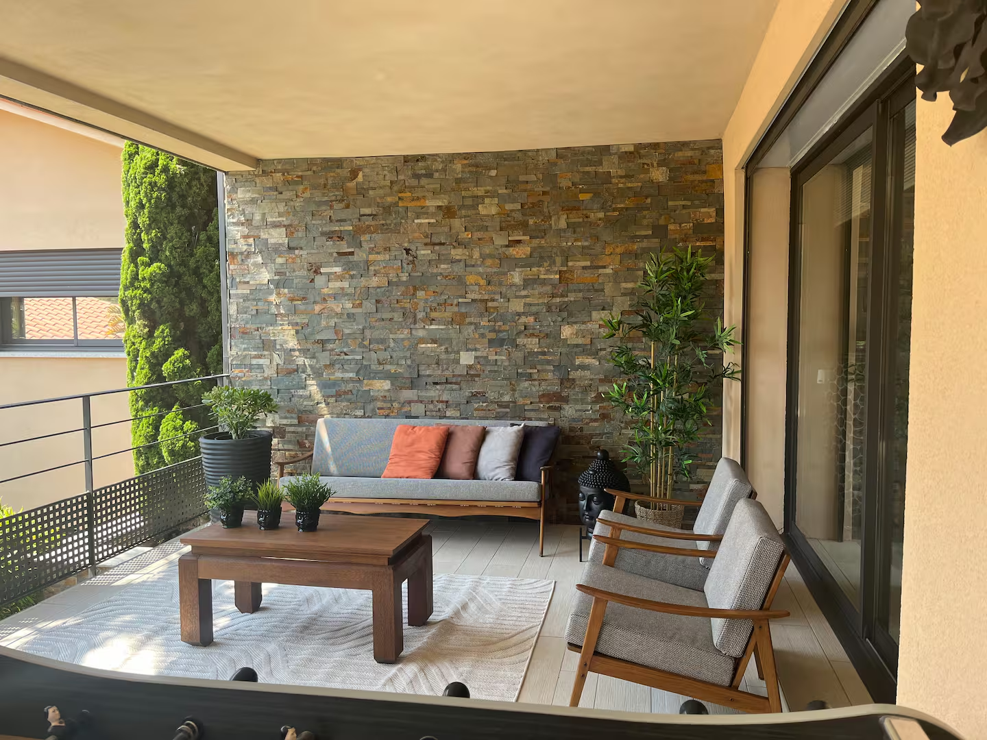Covered terrace lounge with stone wall and seating area